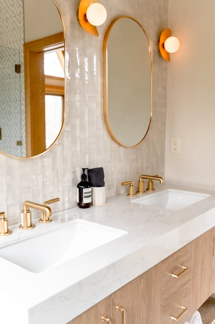 creative-03 Stylish bathroom interior featuring double sinks and gold fixtures with modern mirrors.