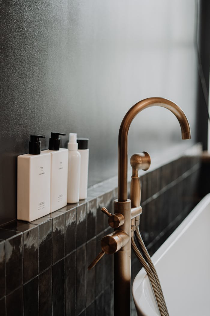 creative-03 Sleek modern bathroom featuring a golden water tap and minimalist bottles.