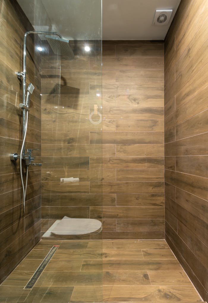 digital-01 Elegant wooden-themed shower stall with clean glass partition in a modern bathroom setting.
